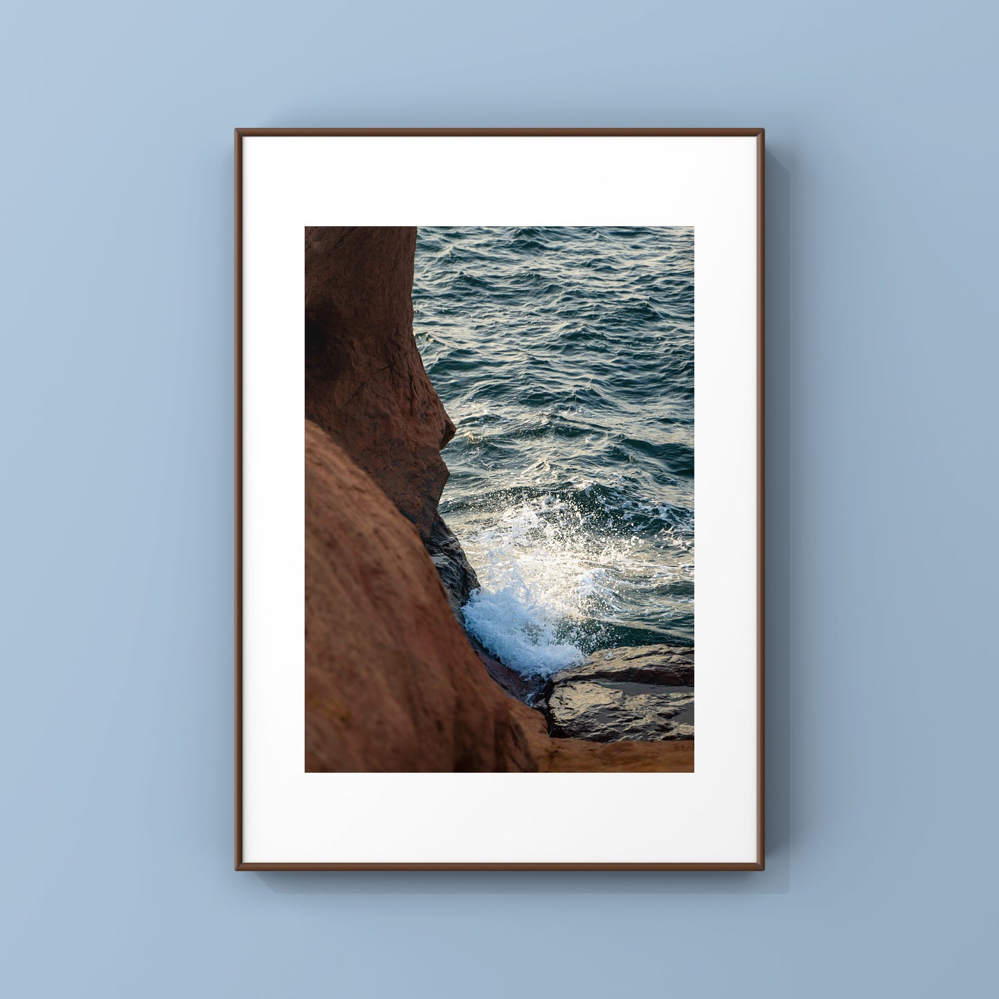 Photography print of a waves splashing on the rocky orange cliffs of Magdalen Islands in Quebec