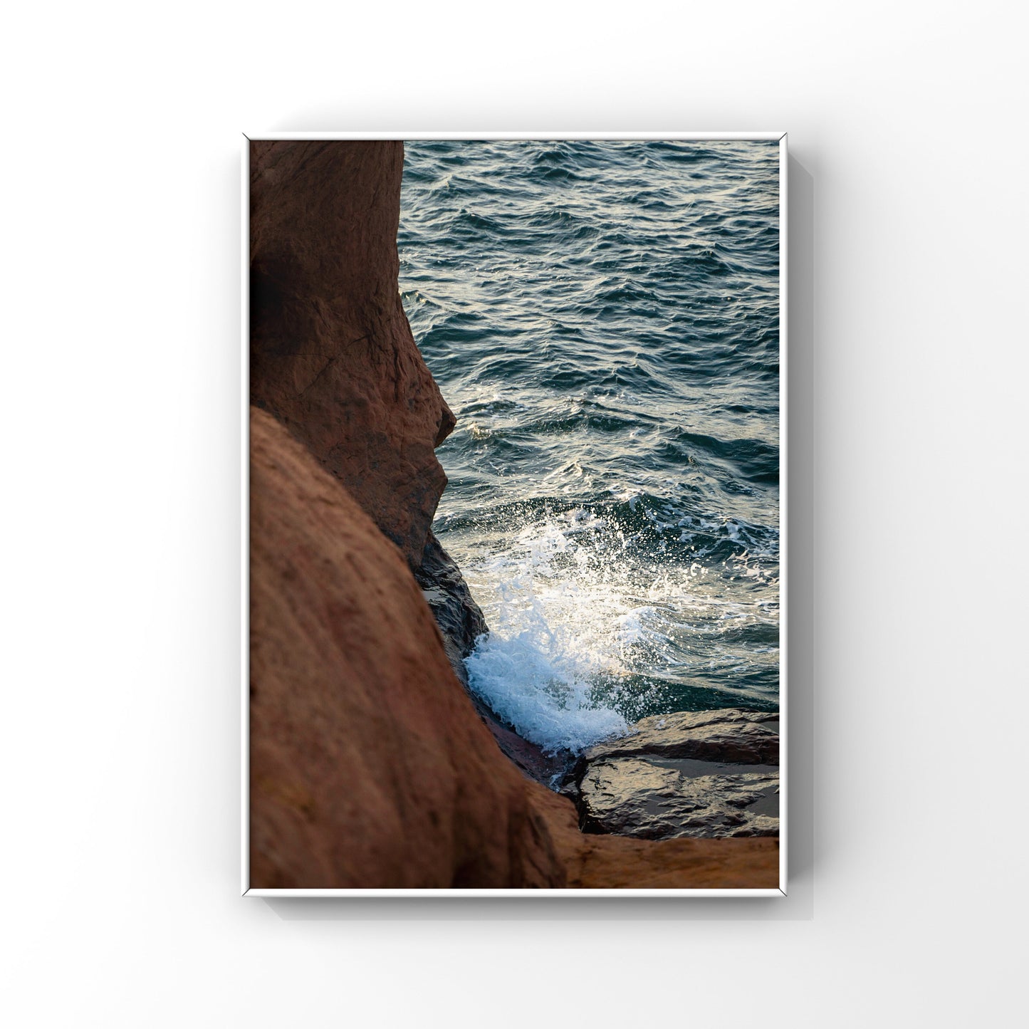 Photography print of a waves splashing on the rocky orange cliffs of Magdalen Islands in Quebec