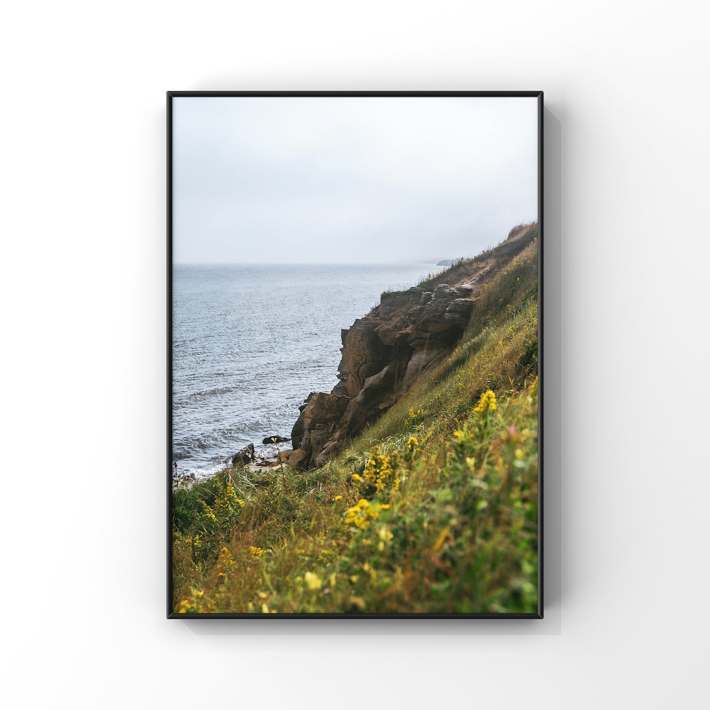 Luscious green and yellow vegetation embracing the rocky cliffs of Magdalen Islands in QUebec