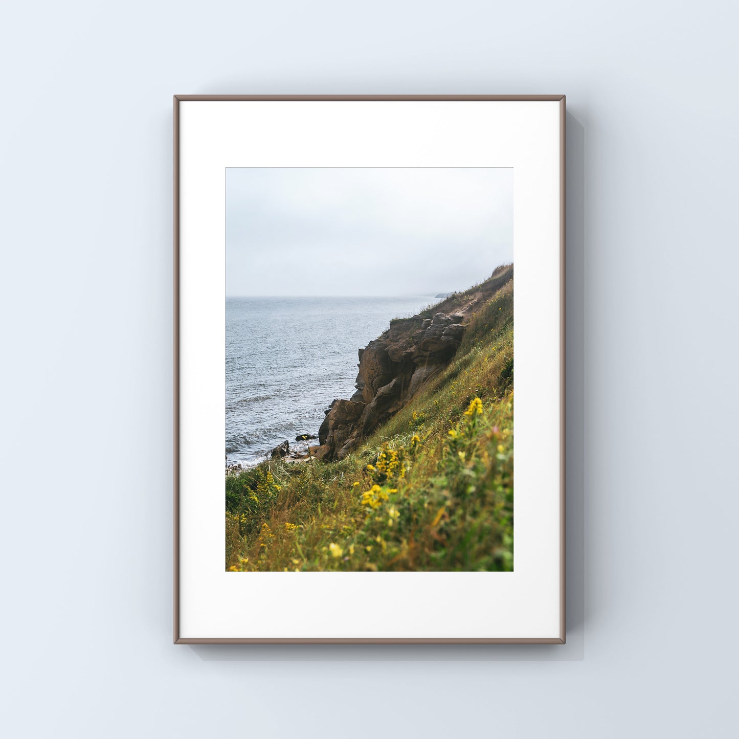 Luscious green and yellow vegetation embracing the rocky cliffs of Magdalen Islands in QUebec